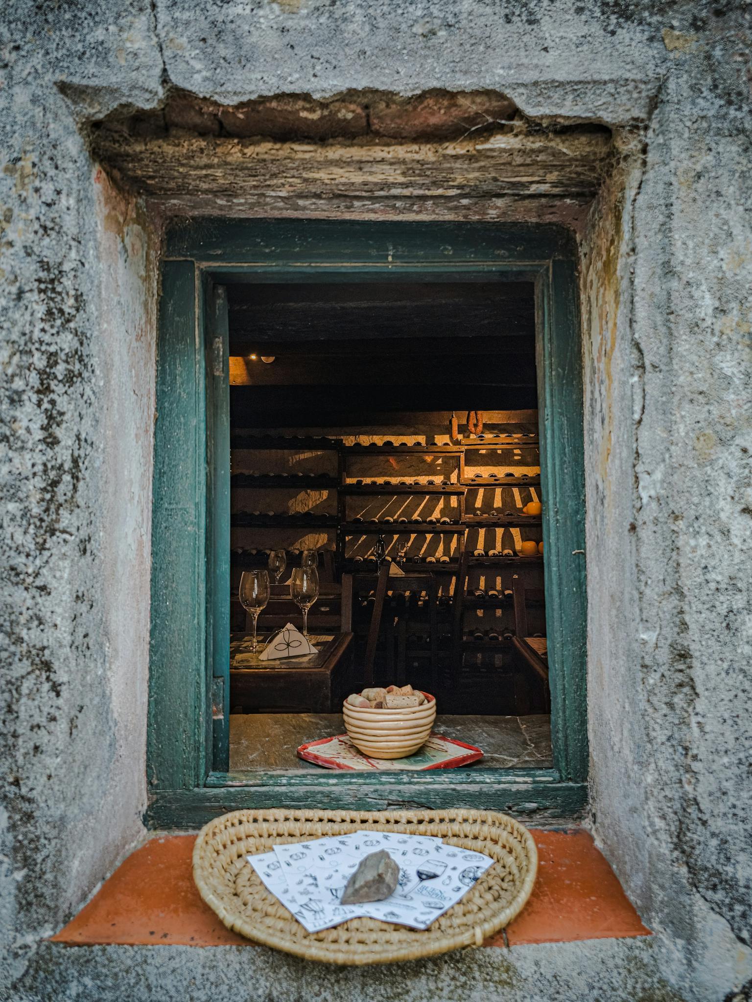 A rustic window reveals a cozy winery in Colonia del Sacramento, Uruguay.