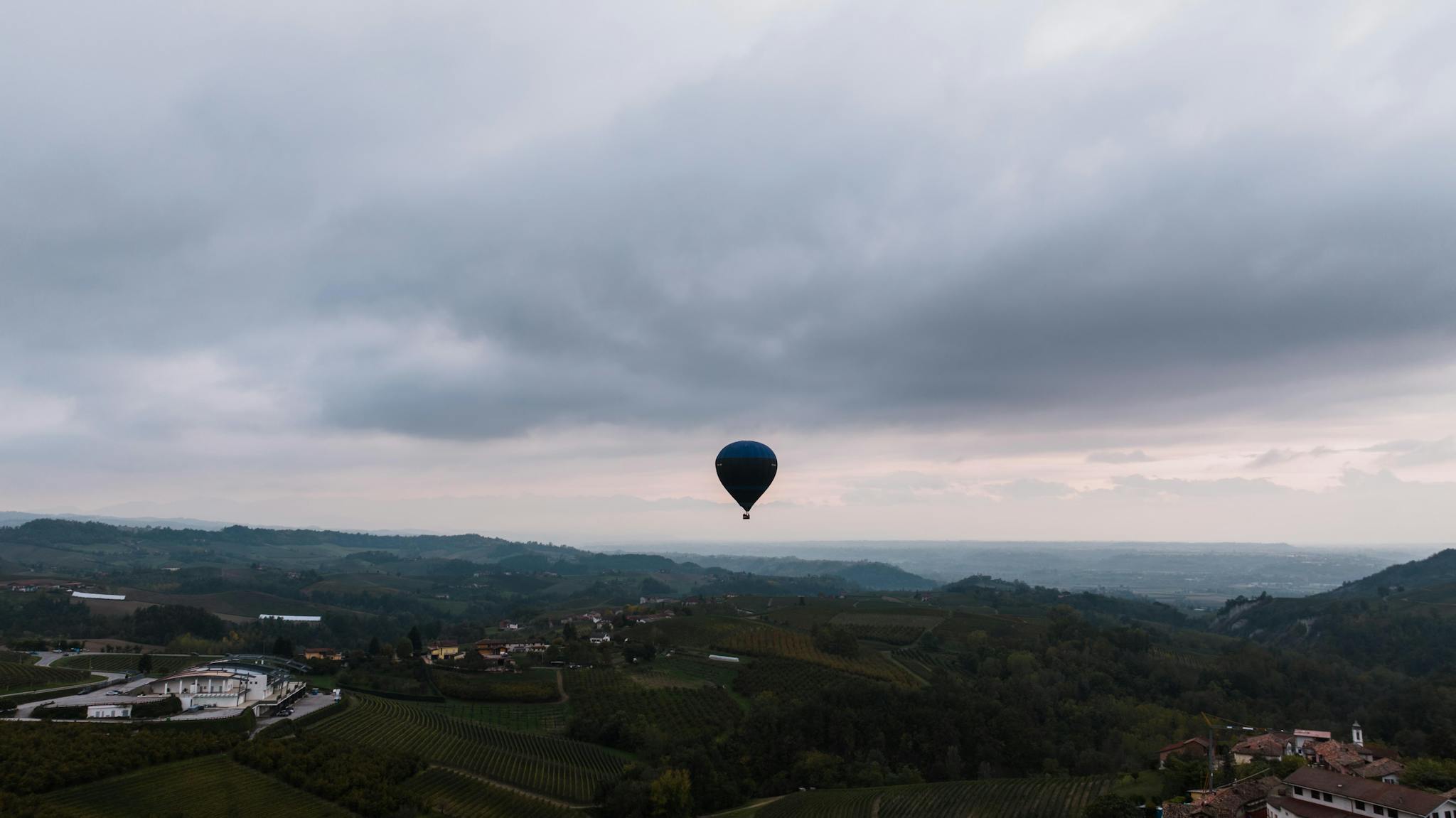 Majestic hot air balloon floating over Monforte D'Alba vineyards in Piemonte, Italy.